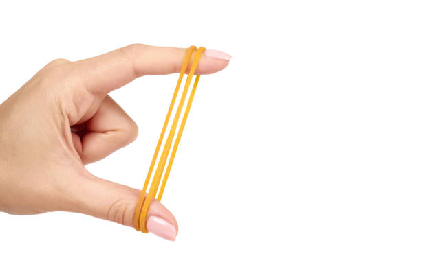 istock Yellow rubber bands close up with hand isolated on white background, copy space template. 1062894298