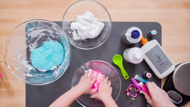 Mother and daughter making colorful fluffy slime. Step by step. Flat lay. Mother and daughter making colorful fluffy slime. slimy stock pictures, royalty-free photos & images