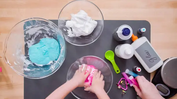 Photo of Mother and daughter making colorful fluffy slime.