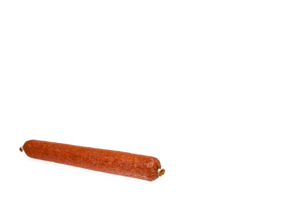 istock smoked salami sausage piece isolated on white background, copy space template 1062894416