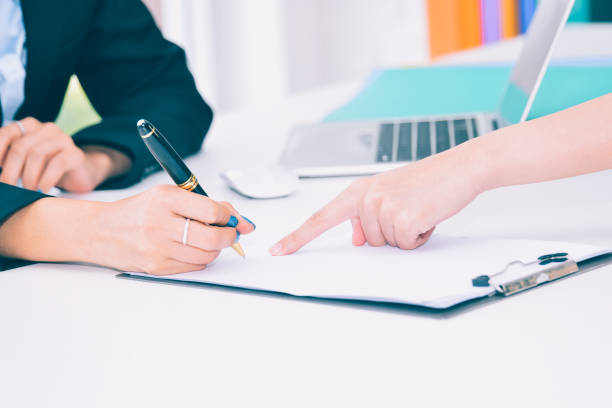 istock female business hand signing contract document in office. 1062897054