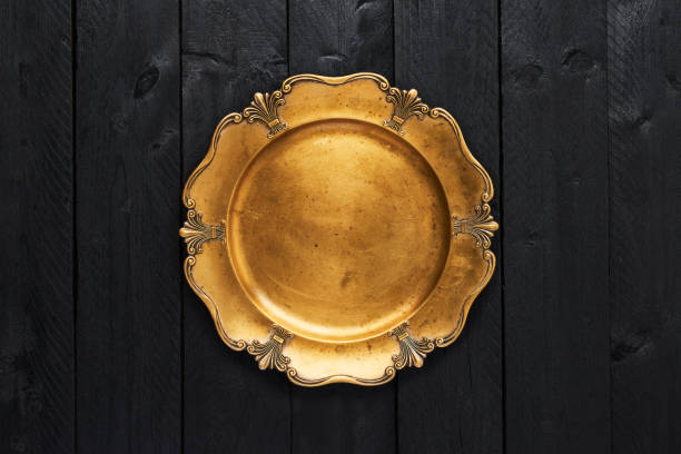 istock Old golden serving plate on black wooden table 1062900632