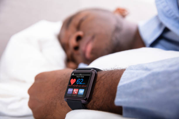 Man Sleeping With Smart Watch In His Hand Close-up Of A Man Sleeping With Smart Watch In His Hand Showing Heartbeat Rate tracker stock pictures, royalty-free photos & images