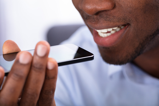 Close-up Of An African Man Using Voice Assistant On Cellphone