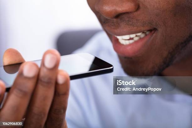 Man Using Voice Assistant On Cellphone Stock Photo - Download Image Now - Voice, Searching, Speech