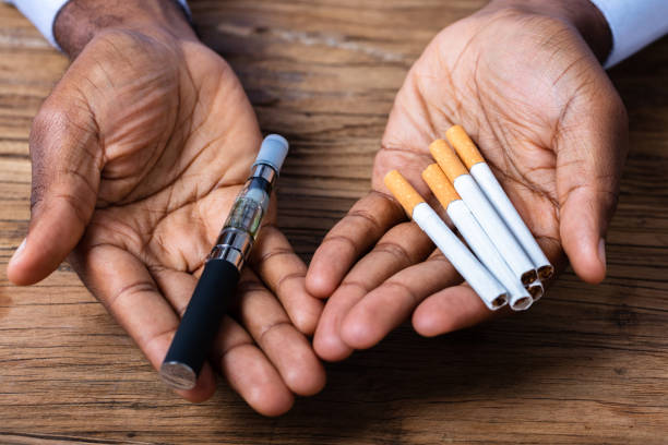 istock Man Holding Vape And Tobacco Cigarettes 1062906916