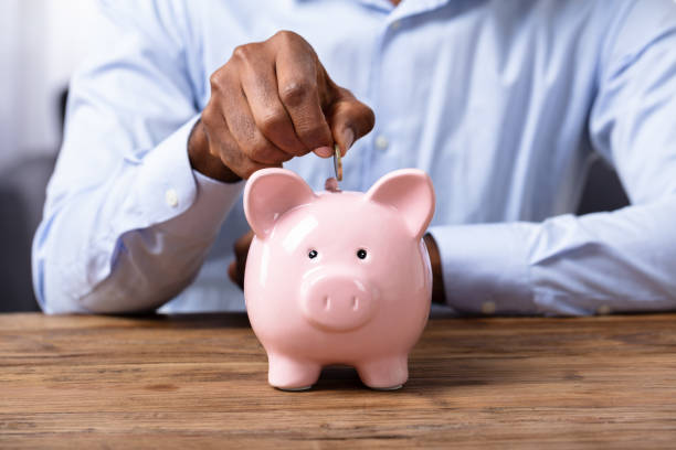 istock Man Inserting Coin In Piggybank 1062906954