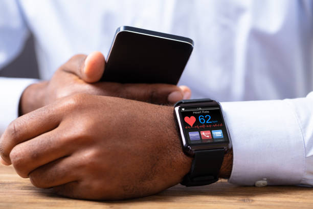 istock Man Holding Mobile Phone With Smartwatch Showing Heart Rate 1062906976