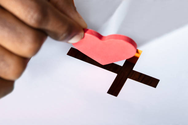 istock Man Inserting Heart Shape In Crucifix Slot 1062907024