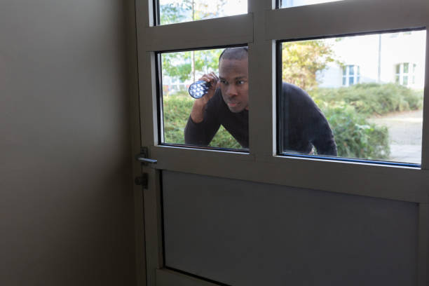 istock Man Peeking Through Glass Door 1062907178