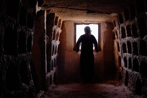 istock MYSTERIOUS MAN WITH TUNIC AND PALESTINIAN SCARF IN A OLD CAVE LOOKING FOR A WINDOW 1062907220