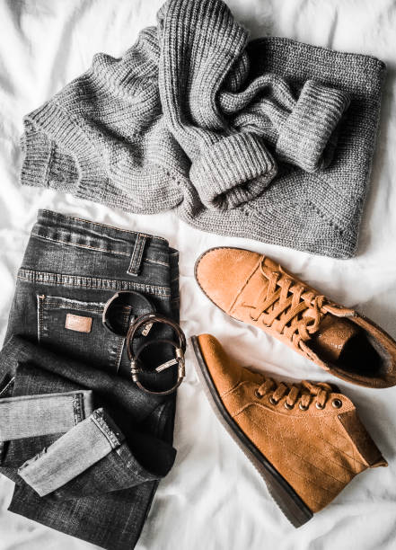 istock Set of women's autumn, winter clothes on a light background - jeans, gray pullover oversize, suede brown boots and scarf. Fashionable clothes for walks, flat lay 1062912522