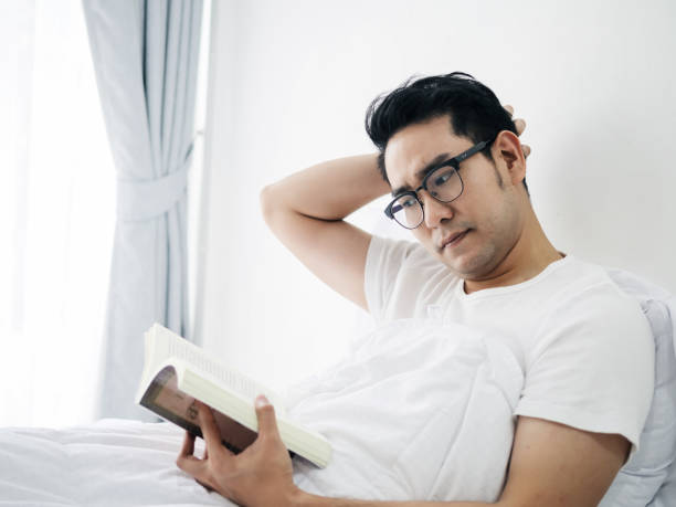 istock Asian man reading a book on bed in weekend, lifestyle concept. 1062914508