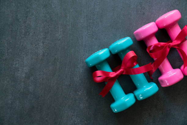 istock dumbbell with red gift bow on a black table background, sport and healthy concep 1062923760
