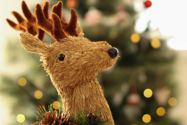 istock Christmas time: Adorable Santa reindeer with blurry Christmas tree background 1062924208