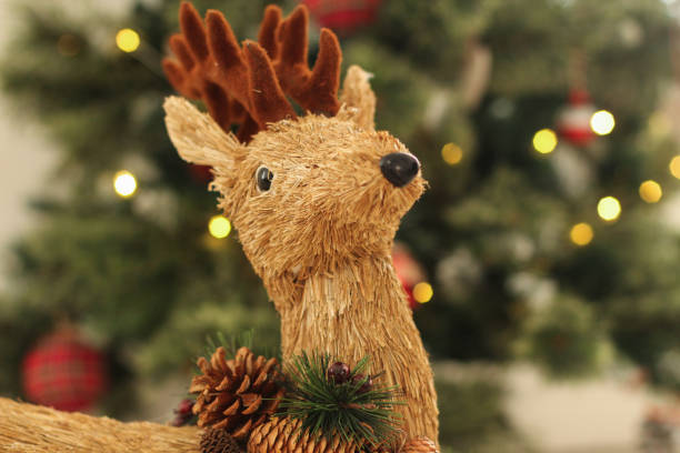 istock Christmas time: Adorable Santa reindeer with blurry Christmas tree background 1062924216