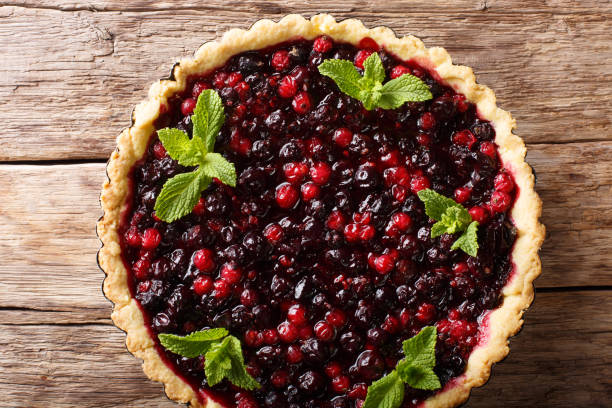 istock Rustic juicy tart with currant berries, blueberries and cranberries close-up on a table. Horizontal top view from above 1062930286