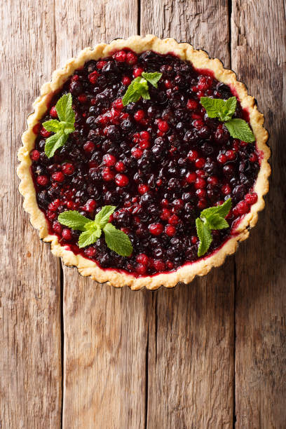 istock open pie with summer berries is decorated with peppermint close-up in a baking dish. vertical top view 1062930306