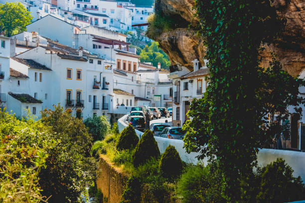 Buildings constructed under big rock natural formations in Setenil de las Bodegas. Houses and shops are carved into the rock, providing natural cooling.