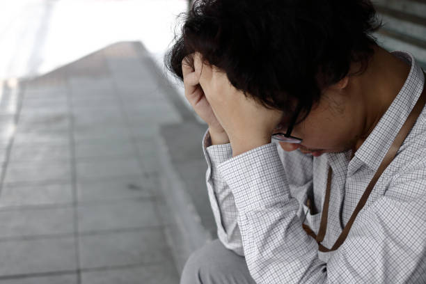 istock Tired stressed young Asian business man in depression with hands on forehead 1062937992