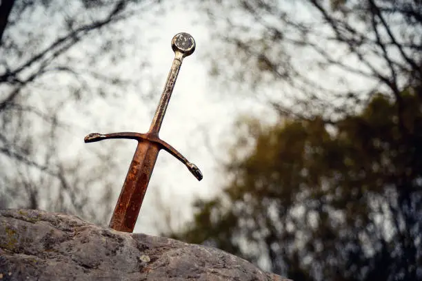 Excalibur the famous sword in the stone of king Arthur in the forest, Llangorse Lake, Brecon Beacons