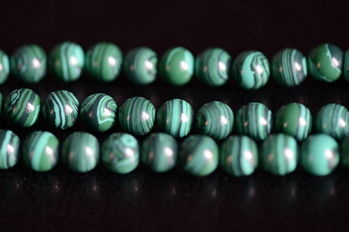 Malachite stone beads necklace on a dark background close up