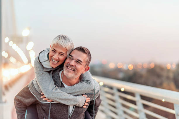 istock Man giving his smiling wife a piggy back 1062948358