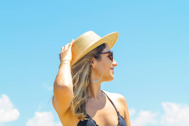 istock Young summer woman wearing hat and sunglasses at the beach 1062951338