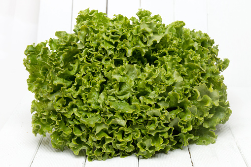 Fresh lettuce isolated on a white wooden background.
