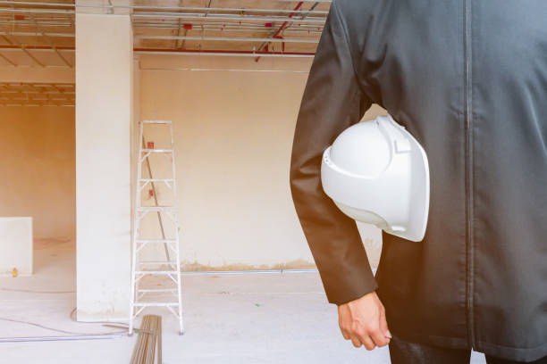 istock engineering businessman hand holding white safety hat interior  Construction site building housing with copy space add text 1062960812