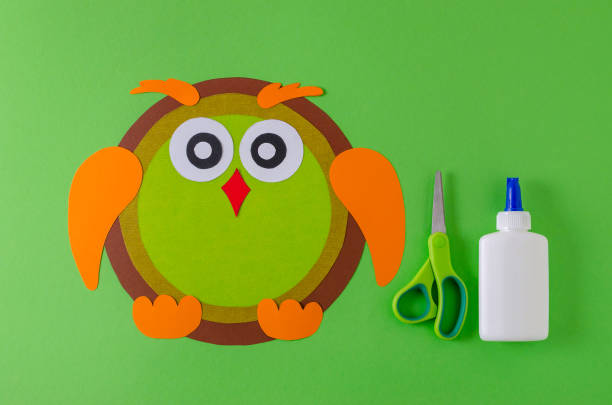 istock making a owl with color paper, glue and scissors on green 1062966124