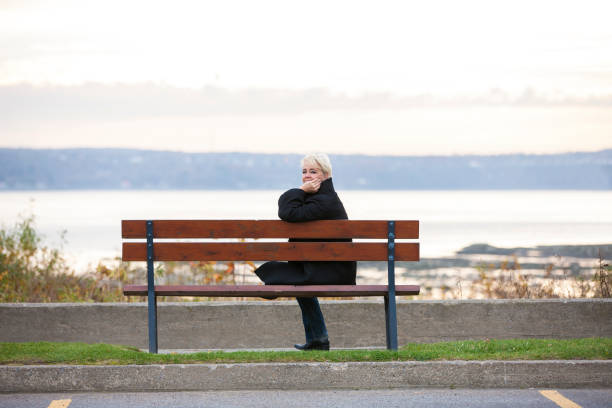 istock Mature woman sitting on park bench. 1062968444