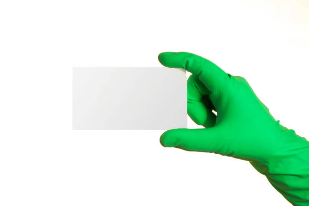 istock A hand in a green glove holding a sticky note with space for text, on a white background 1062969056
