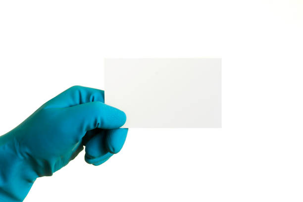 istock Hand in a blue glove holding a sticky note with space for text, on a white background 1062973532