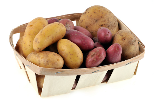 Crate of different potatoes on a white background