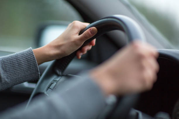 istock Driver's hands driving a car on a highway 1062989126