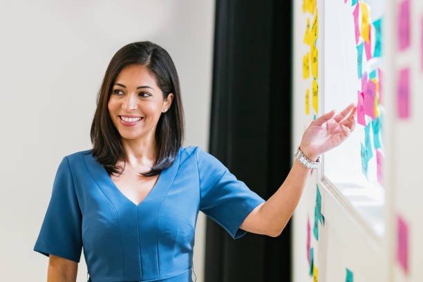 Smiling Hispanic Businesswoman Presenting Sticky Notes Ideas