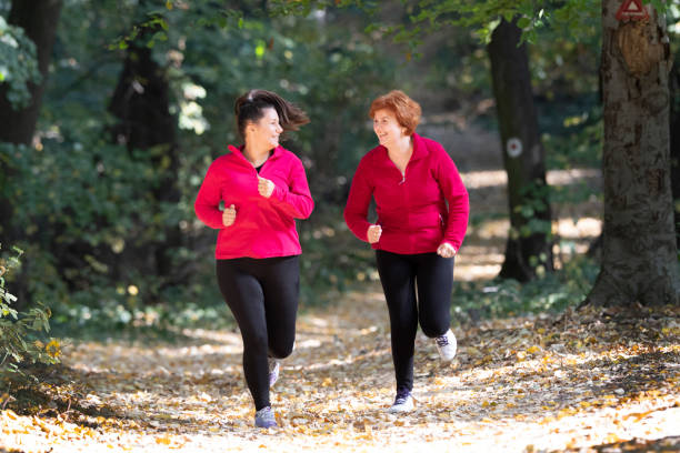 スポーツ ウエアを着ていると山で森で実行されている母と娘 - active seniors women senior adult mature adult ストックフォトと画像