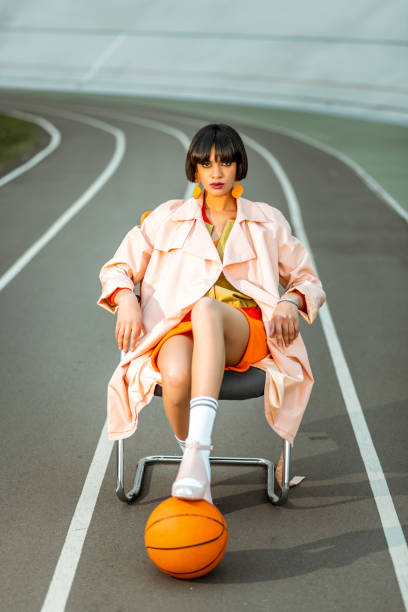 serious formal girl siting on the chair in the middle of the stadium - earring multi colored shoe jewelry imagens e fotografias de stock