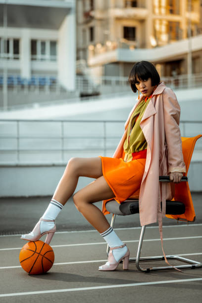 istock Drastic woman sexually posing with orange ball 1063022156