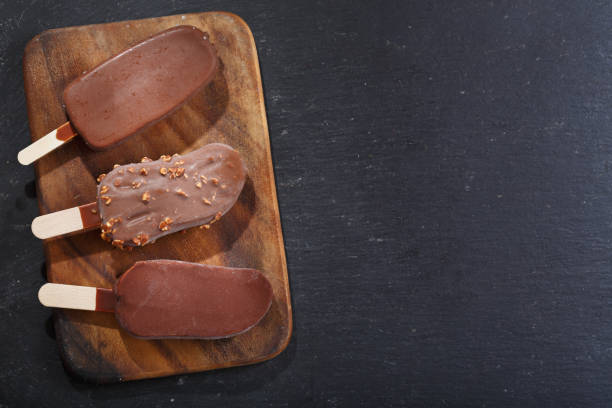 istock ice cream bar covered with chocolate on wooden board 1063022968