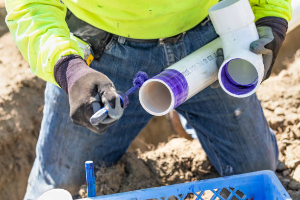 istock Plumber Applying Pipe Cleaner, Primer and Glue to PVC Pipe At Construction Site 1063027954
