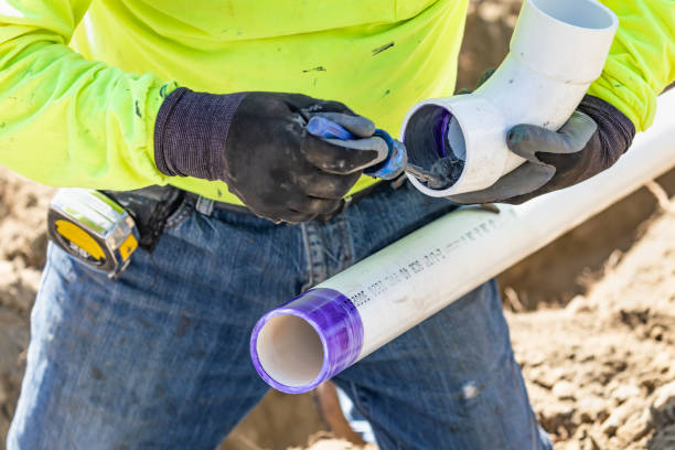 istock Plumber Applying Pipe Cleaner, Primer and Glue to PVC Pipe At Construction Site 1063027968
