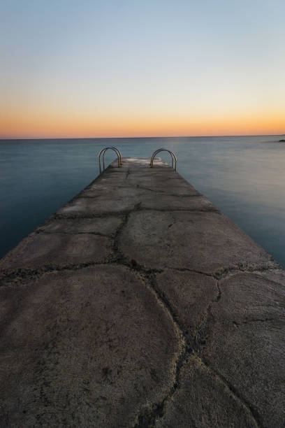istock A small pier shrouded in warm light and surrounded by ocean 1063032310