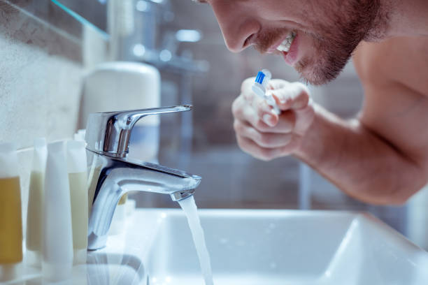 istock Young handsome bearded man brushing his teeth before going to bed 1063044332