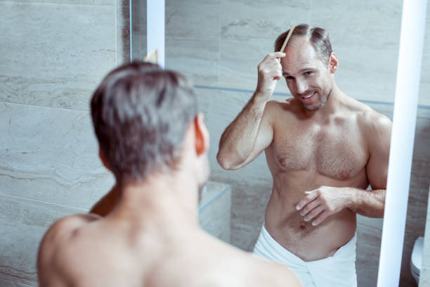 istock Handsome blonde-haired man combing his hair getting ready for work 1063044392