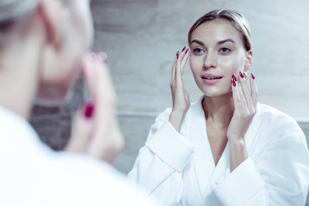 istock Blonde-haired appealing woman using nourishing cream for her face 1063044470