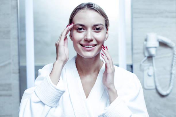 istock Beaming blonde-haired woman with red nails doing face massage 1063044476