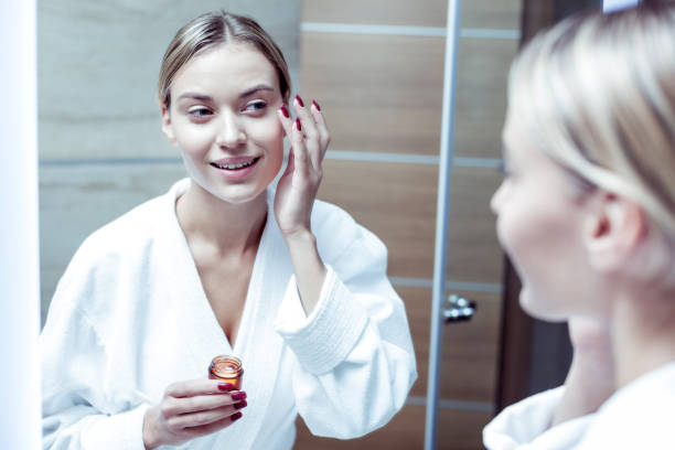 istock Young good-looking woman putting some cream under her eyes 1063044514