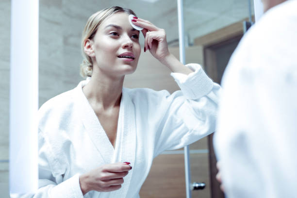 istock Appealing beautiful woman wearing white bathrobe standing in bathrobe 1063044536